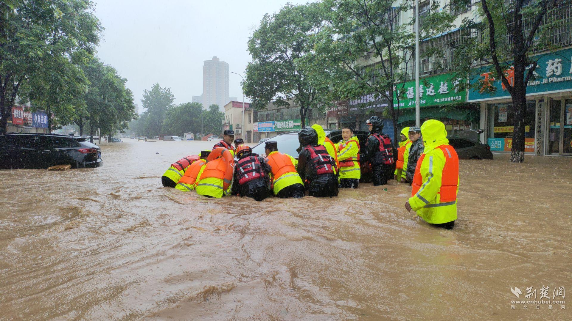 7月14日，湖北省丹江口市城區(qū)路面大面積嚴(yán)重積水，一輛黑色SUV轎車被洪水沖至馬路中央無法動彈。為最大程度減少群眾損失，當(dāng)?shù)孛窬? data-origin-src=